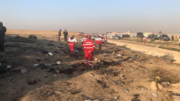 <p>Rettungskräfte stehen am Ort eines Flugzeugabsturzes am Rande von Teheran.</p>