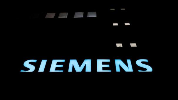 <p>Hinter einige Fenstern ist am Eingang des Werkes von Siemens Licht zu sehen. Der Industriekonzern hält trotz Protesten von Klimaschützern an einer wichtigen Zulieferung für ein umstrittenes Kohlebergwerk in Australien fest.</p>