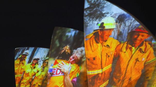 <p>Auf den großen Segeln des Opernhauses werden als Dank und Zeichen der Solidarität Bilder von Feuerwehrleuten auf die großen Segel der Oper in Sydney projiziert.</p>