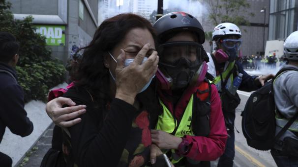 <p>Eine weinende Demonstrantin wird an einen Straßenrand geführt. Seit einem halben Jahr demonstrieren die Hongkonger gegen die Regierung, den wachsenden Einfluss Peking und unverhältnismäßig hartes Vorgehen der Polizei.</p>