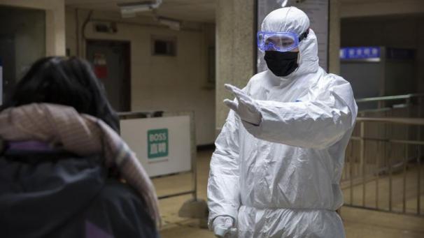 <p>Ein Mitarbeiter trägt einen Sicherheitsanzug und weist einen Fahrgast in einer U-Bahn-Station an. Im Kampf gegen die Krankheit hatte China gestern kurz vor dem chinesischen Neujahrsfest rund 20 Millionen Menschen praktisch unter Quarantäne gestellt.</p>