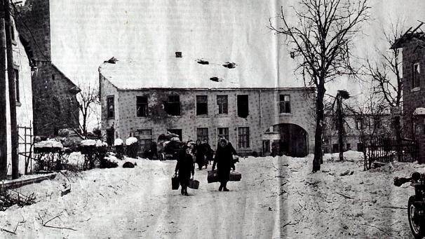 <p>Originalaufnahme aus dem Januar 1945: Die noch verbliebenen Einwohner ergreifen die Flucht oder suchen Schutz in Kellern. Links im Bild erkennt man die Ameler Pfarrkirche, deren Turm am 23. Januar nach massivem Beschuss eingestürzt war.</p>