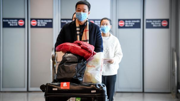 <p>Chinesische Fluggäste mit Mundschutzmasken nach ihrer Landung im Pariser Flughafen Charles De Gaulle.</p>