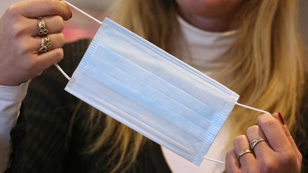 <p>Eine Apothekerin hält eine Atemmaske in der Hand.</p>