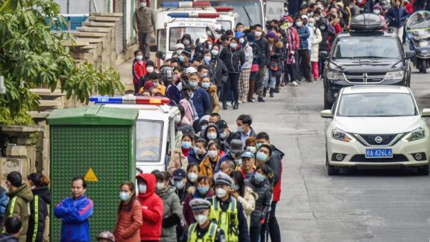<p>Menschen mit Mundschutz stehen vor einem Sanitätshaus in Nanjing an.</p>