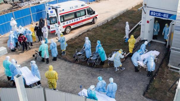 <p>Mediziner helfen Patienten, die mit dem neuartigen Coronavirus infiziert sind, in das Huoshenshan Hospital.</p>