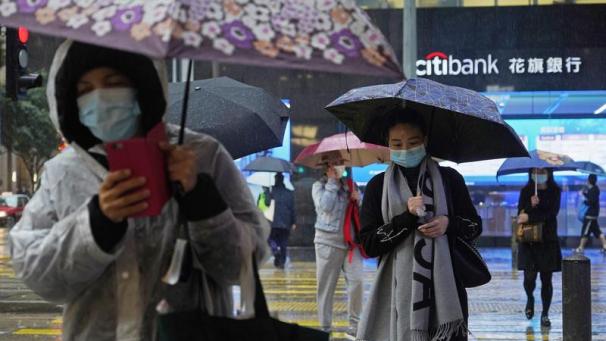 <p>Passanten tragen Gesichtsmasken und gehen bei Regen über eine Straße. Die Zahl neu nachgewiesener Todesopfer durch das Coronavirus hat sich in China in der besonders schwer betroffenen Provinz Hubei im Vergleich zum Vortag mehr als verdoppelt.</p>