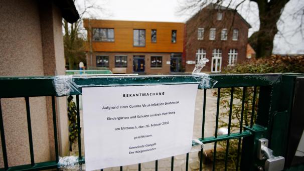 <p>Ein Schild „Bekanntmachung. Aufgrund einer Corona-Virus-Infektion bleiben die Kindergärten und Schulen im Kreis Heinsberg am Mittwoch, den 26. Februar 2020, geschlossen. Gemeinde Gangelt. Der Bürgermeister.“</p>