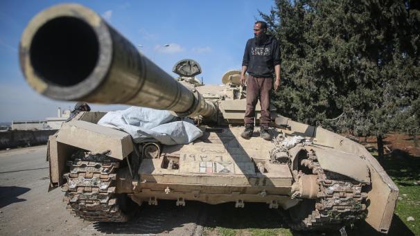 <p>Ein Kämpfer der Nationalen Befreiungsfront (NFL) steht auf einem Panzer der syrischen Regierungstruppen.</p>