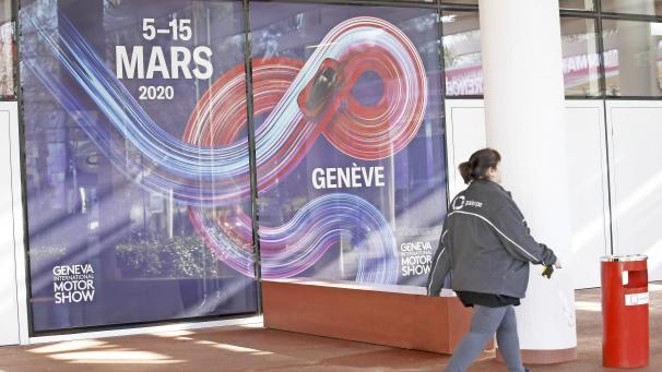 <p>Eine Arbeiterin geht an einen Banner mit Werbung zum 90. Genfer Autosalon am Veranstaltungsort Palexpo entlang. Wegen der steigenden Zahl von Coronavirus-Fällen untersagt die Schweiz vorerst alle Großveranstaltungen mit mehr als 1.000 Menschen. Dazu gehören unter anderem der Genfer Autosalon.</p>