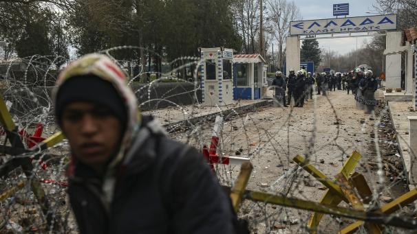 <p>Griechische Polizisten bewachen die Grenze zu Griechenland während ein Migrant vor dem Grenzübergang steht. Griechenland wird weiter die Grenze Europas zur Türkei verstärkt überwachen und illegale Einreisen in die EU verbieten.</p>