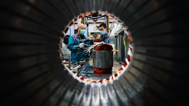 <p>China, Hubei, Shijiazhuang: Mitarbeiter mit Mundschutz arbeiten in einem Werk eines Unternehmens, das mechanische und elektronische Produkte herstellt.</p>