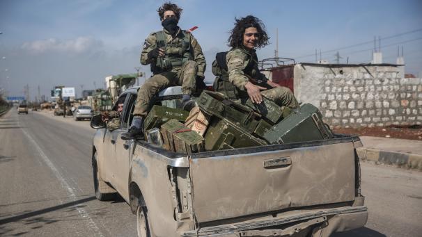 <p>Syrien, Sarakib: Kämpfer der Nationalen Befreiungsfront (NFL) patrouillieren auf einer Straße.</p>