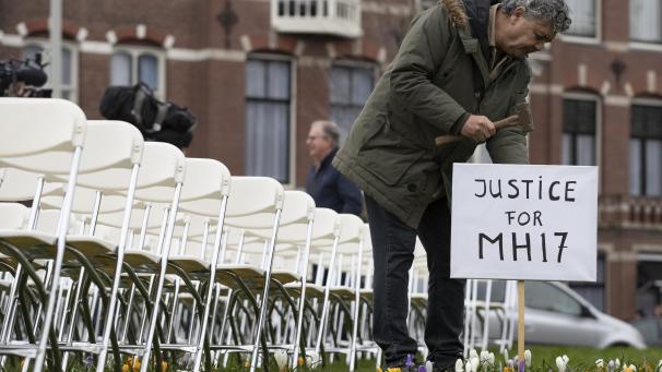 <p>8. März 2020, Niederlande, Den Haag: Rob Fredriksz, der seinen Sohn Bryce und seine Freundin Daisy verloren hat, stellt ein Schild neben 298 leeren Stühlen auf, in einem Park gegenüber der russischen Botschaft. Jeder Stuhl steht für eines der 298 Opfer des abgestürzten Malaysia Air-Fluges MH17.</p>