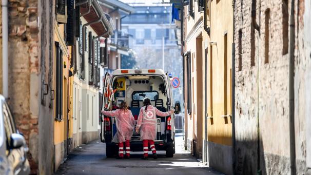 <p>Italien, Codogno: Zwei Rettungsdienstmitarbeiterinnen öffnen die Türen eines Krankenwagens.</p>