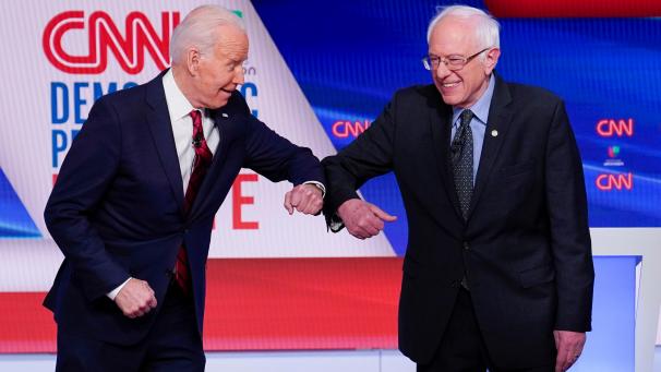 <p>Bernie Sanders (r.), Senator und Bewerber um die Präsidentschaftskandidatur der Demokraten, und Joe Biden, ehemaliger US-Vizepräsident und ebenfalls Bewerber um die Präsidentschaftskandidatur der Demokraten, begrüßen sich aufgrund der Ansteckungsgefahr durch Covid-19 in den CNN-Studios mit den Ellenbogen.</p>