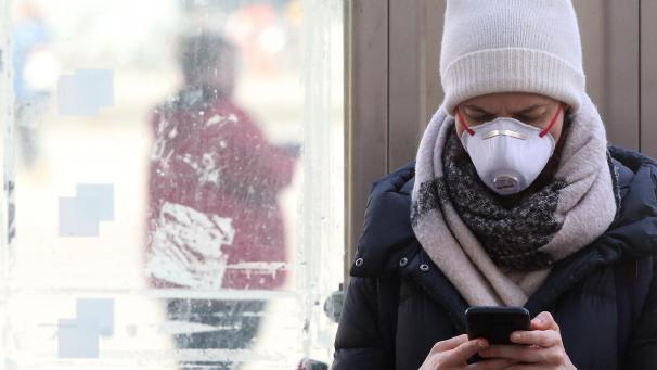 <p>Berlin: Eine junge Frau mit Schutzmaske informiert sich auf dem Alexanderplatz im Bezirk Mitte mit ihrem Smartphone über die Nachrichtenlage und über die weitere Entwicklung beim Coronavirus.</p>