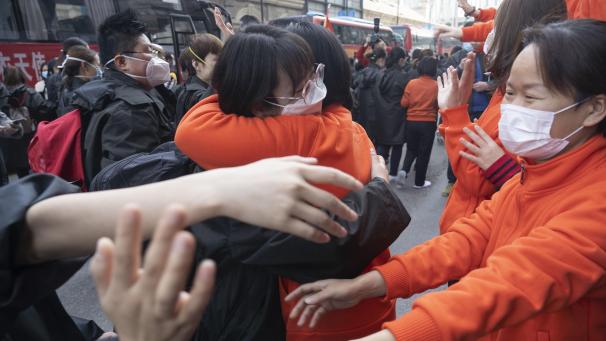 <p>China, Wuhan: Medizinische Mitarbeiter mit Mundschutzmasken aus der ostchinesischen Provinz Jiangxi (in orange) verabschieden sich in der chinesischen Millionenmetropole Wuhan von Mitarbeitern aus der nordwestchinesischen Provinz Qinghai.</p>