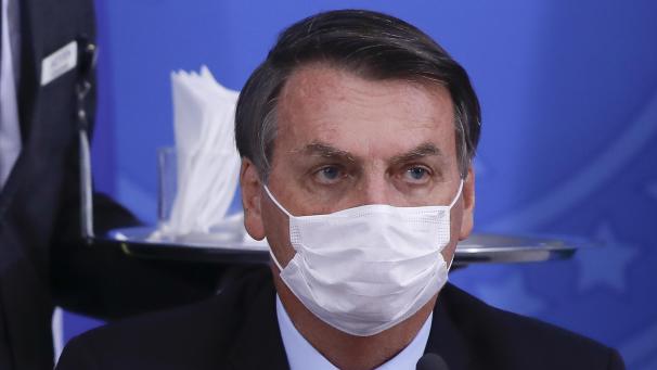 <p>Brasiliens Präsident Jair Bolsonaro trägt während einer Pressekonferenz zum Coronavirus eine Mundschutzmaske.</p>