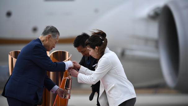 <p>Yoshiro Mori (l.), Präsident des Tokio-Organisationskomitees, empfängt die olympische Flamme von den japanischen dreimaligen olympischen Goldmedaillengewinnern Saori Yoshida (r.) und Tadahiro Nomura (M.), die die Flamme von Griechenland nach Japan transportiert haben.</p>