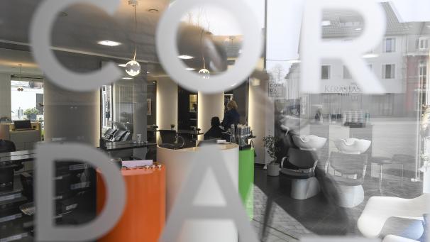 <p>Eine Friseurin im Salon „Corda Coiffure“ bedient eine einizige Kundin. Wegen der bestehenden Regelung darf auch unser Fotograf nicht hinein.</p>