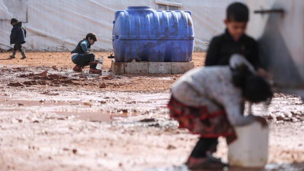 <p>Kinder füllen in einem provisorischen Lager für Familien, die infolge der Bombardierung und der Militäroperationen aus dem Idlib-Land vertrieben wurden, Behälter mit Wasser auf.</p>