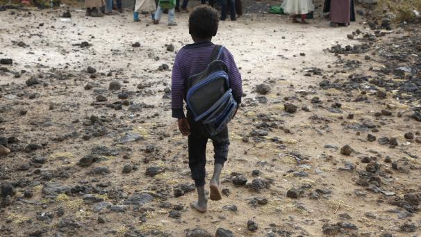 <p>Ein jemenitisches Flüchtlingskind geht in einem Lager am Rande von Sanaa barfuß zur Schule.</p>