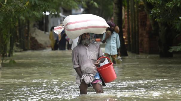 <p>Ein Mann bahnt sich am 20. Juli 2020 in Dhaka, Bangaldesch, seinen Weg durch die Fluten.</p>