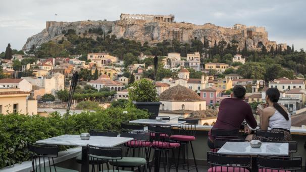 <p>Athen: Gäste sitzen in einem Cafe im Stadtteil Monastiraki mit der Akropolis im Hintergrund.</p>