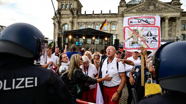 <p>Teilnehmer einer Kundgebung gegen die Corona-Maßnahmen stehen vor dem Reichstag.</p>