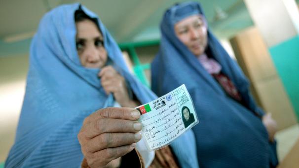 <p>Afghanische Frauen warten mit ihren Ausweisen in der Hand in einer Moschee in Kabul.</p>
