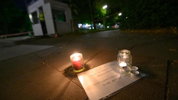<p>Ein Schild mit der Aufschrift „Für eine offene und tolerante Gesellschaft - Antisemitismus hat hier keinen Platz“ liegt neben Kerzen und Blumen auf dem Gehweg nahe der Synagoge. In der Nähe der Synagoge in Hamburg ist es am Sonntagnachmittag zu einem Angriff gekommen, bei dem ein 26 Jahre alter Mann erheblich verletzt wurde.</p>