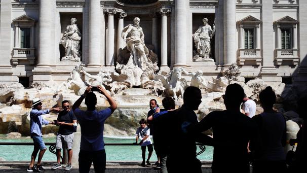 <p>Italien, Rom: Touristen fotografieren den Trevi-Brunnen. Angesichts steigender Infektionszahlen wappnen sich manche Länder mit neuen Regeln.</p>