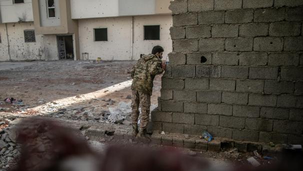 <p>Ein Kämpfer der international anerkannten Regierung schaut während der Zusammenstöße mit den Truppen der Libysch-Nationalen Armee (LNA) um eine Mauer.</p>