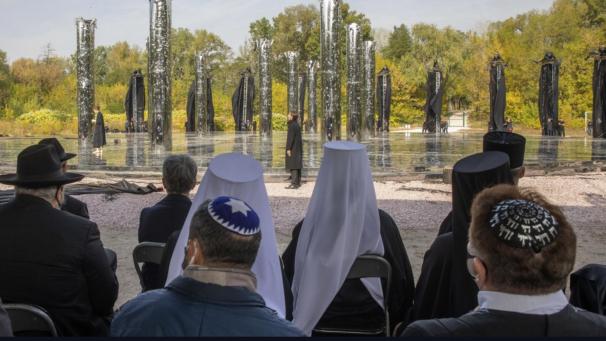 <p>Ukraine, Kiew: Kleriker besichtigen eine Kunstinstallation bei einer Gedenkveranstaltung an der Gedenkstätte Babi Jar. Deutsche Truppen ermordeten während der Besatzung der ukrainischen Hauptstadt an dem Ort im September 1941 über 33.000 Menschen.</p>