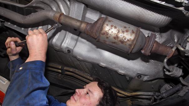 <p>Ein Automechaniker demontiert einen Rußpartikelfilter.</p>