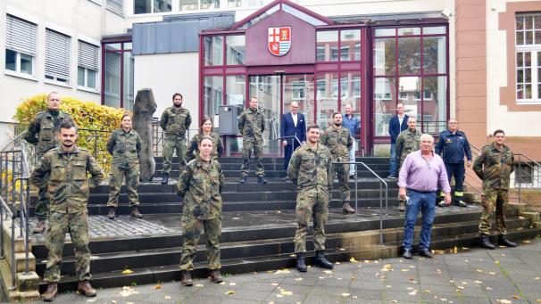 <p>Der 1. Beigeordnete des Kreises Bitburg-Prüm, Michael Billen, mit den Unterstützungskräften der Bundeswehr vor der Kreisverwaltung in Bitburg</p>
