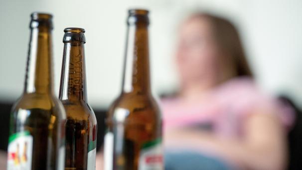 <p>Eine junge Frau sitzt hinter leeren Bierflaschen. Die Corona-Pandemie verstärkt auch in Ostbelgien das Suchtverhalten. „Der Medikamenten- und Alkoholmissbrauch hat im Sommer um schätzungsweise 20 Prozent zugenommen“, sagt Yvonne Verheugen, Psychiatrie-Managerin der Klinik St. Josef in St.Vith.</p>