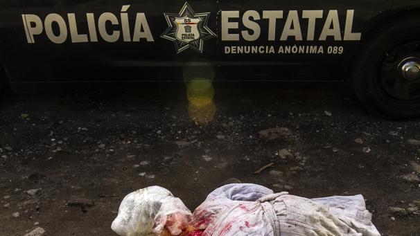 <p>Eine mit rot gefärbte Puppe liegt auf der Straße. Die Puppe trug eine Drohnachricht, die an Drogenverkäufer adressiert war. Neben dem Drogenhandel sei die soziale Ungleichheit der Hauptgrund für die Gewalt und Kriminalität in Mexiko.</p>
