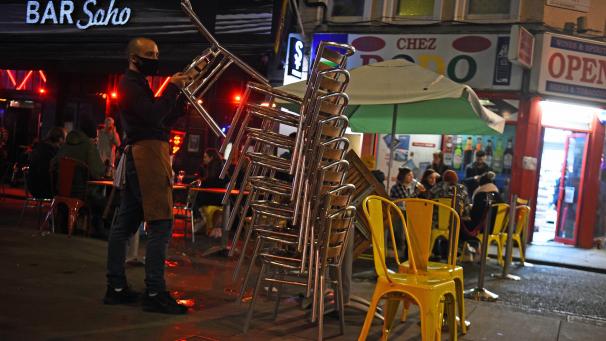 <p>Großbritannien, London: Ein Kellner stellt Stühle vor einer Bar in der Londoner Old Compton Street weg am letzten Abend vor dem Teil-Lockdown. Ab diesem Donnerstag gilt in England zur Bekämpfung der Corona-Pandemie ein Teil-Lockdown.</p>