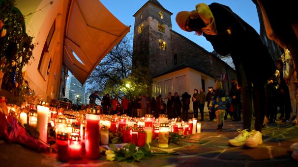 <p>Menschen stehen vor einem Kerzen- und Blumenmeer an einem der Tatorte vor der Ruprechtskirche.</p>