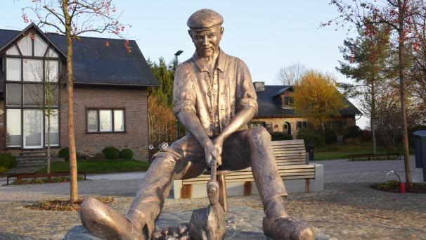 <p>Auf einem einbeinigen Schemel sitzend zeigt sich der „Steeklöpper“ auf dem Weywertzer Kirchplatz. Mit einem langstieligen Hammer schlägt er auf einen dicken Stein. Als Arbeitskleidung trägt die lebensgroße Figur ein „Kamesol“ und eine übliche „Scheremekap“.</p>