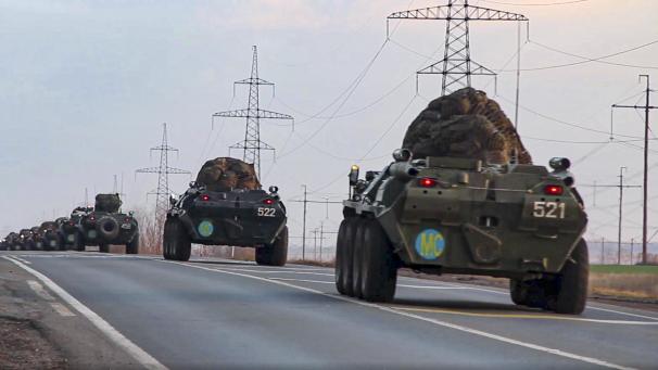 <p>Russische Militärfahrzeuge befördern Friedenstruppen zu einem Flughafen an einem unbekannten Ort in Russland.</p>