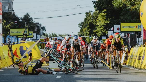 <p>Bei dem zweifelhaften Manöver kam Dylan Groenewegen (vorne links) selbst zu Fall. Vom schwer verletzten Fabio Jakobsen, der hinter der Balustrade landete, ist auf diesem Bild nur am linken oberen Bildrad das Rennrad zu sehen,</p>