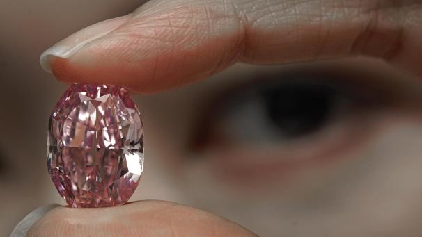 <p>Ein Modell zeigt einen 14,83-karätigen Diamanten, der einer der größten innen makellosen, ausgefallenen, lebhaften lila-rosa Edelsteine ist, der je vom Gemmological Institute of America in einem Auktionssaal bei Sotheby's bewertet wurde.</p>