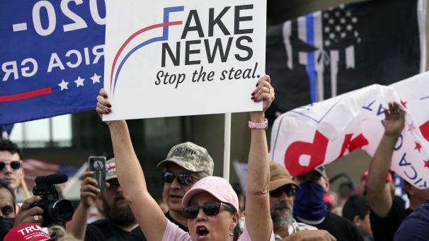 <p>Eine Unterstützerin von US-Präsident Trump hält ein Schild mit der Aufschrift „Fake News, Stop the Steal“ während einer Kundgebung in Dallas hoch, um gegen den Ausgang der Präsidentschaftswahlen zu protestieren.</p>