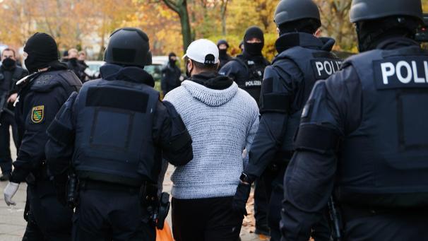 <p>Polizeibeamte bringen bei einem Einsatz in Berlin eine Person zur Identitätsprüfung. Knapp ein Jahr nach dem Kunstdiebstahl im Dresdner Grünen Gewölbe hat die Polizei am Dienstagmorgen in Berlin drei Tatverdächtige festgenommen. Seit dem Morgen wurden insgesamt 18 Objekte durchsucht.</p>