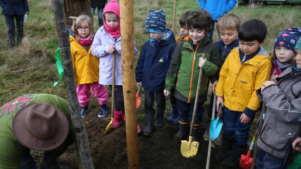 <p>Aufmerksam beobachten die Kinder, wie ein Baum gepflanzt wird – gleich dürfen sie selbst Hand anlegen.</p>