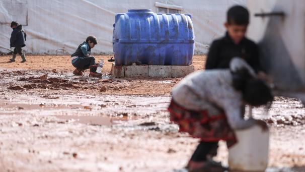 <p>Syrien, Ma'arrat Misrin: Kinder füllen in einem provisorischen Lager für Familien, die infolge der Bombardierung und der Militäroperationen aus dem Idlib-Land vertrieben wurden, Behälter mit Wasser auf.</p>