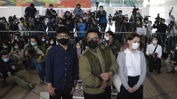 <p>Die Aktivisten Joshua Wong (l-r), Ivan Lam und Agnes Chow stehen bei ihrer Ankunft vor dem Gerichtsgebäude. Die Pro-Demokratie-Aktivisten stehen vor Gericht wegen der Belagerung einer Polizeistation während der Anti-Regierungs-Proteste im vergangenen Jahr.</p>